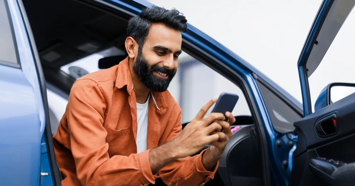 a happy driver access 0% finance on his phone