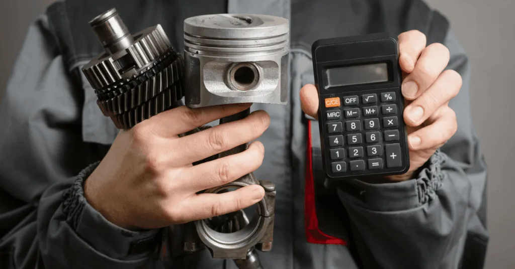 Mechanic holding car engine parts and a calculator, representing increasing car repair costs.