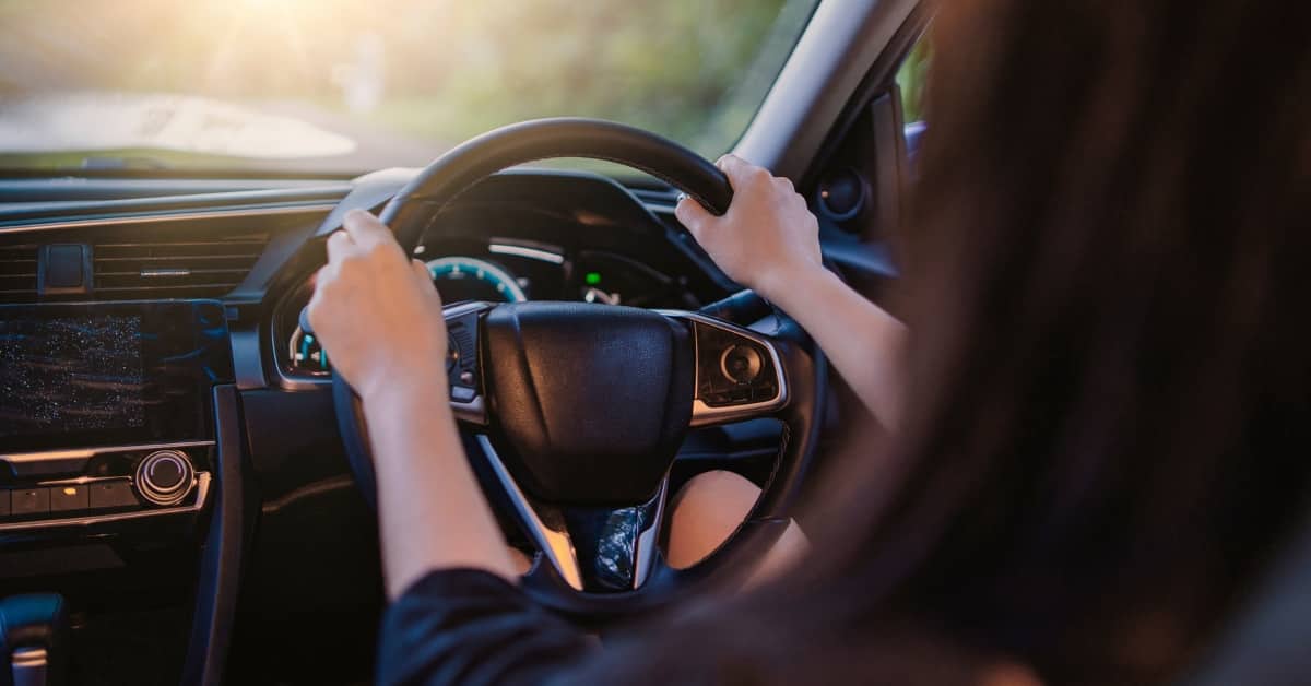 Driver holding the steering wheel inside a car, representing buy now, pay later (BNPL) flexibility for motoring costs.