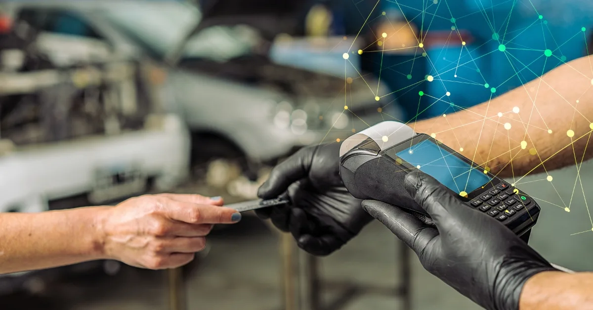 Garage labour costs: Close-up of a card payment being processed in a garage using a handheld payment terminal.