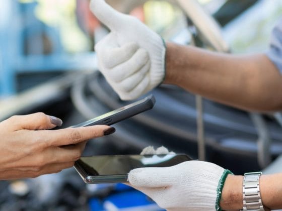 Responsible BNPL for car repairs, Mechanic giving a thumbs up while a customer holds a smartphone, symbolising responsible BNPL for car repairs and digital payment approval.