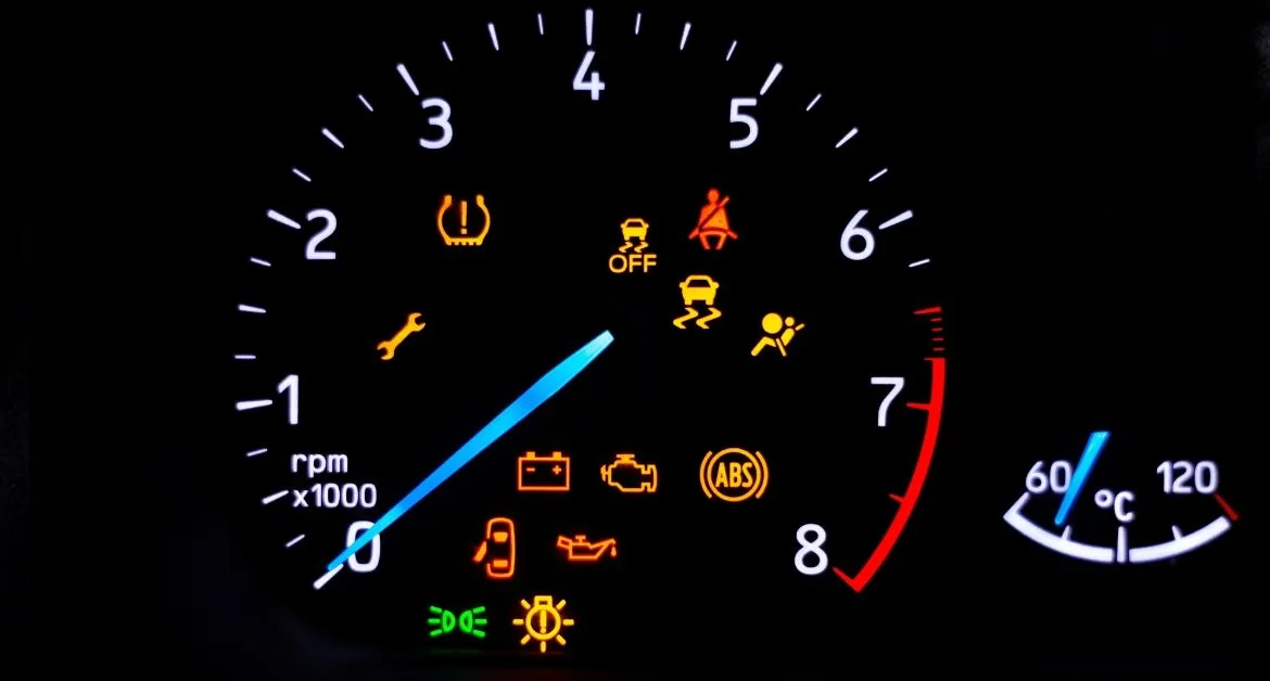 Car warning signs – Car dashboard with illuminated warning lights including tyre pressure, ABS, engine, oil, and seatbelt alerts.