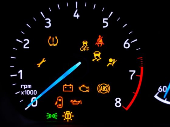 Car warning signs – Car dashboard with illuminated warning lights including tyre pressure, ABS, engine, oil, and seatbelt alerts.