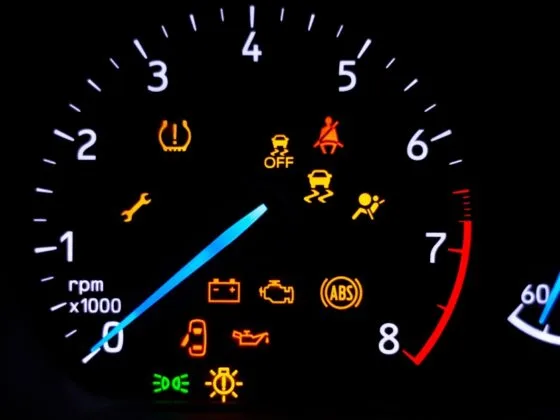 Car warning signs – Car dashboard with illuminated warning lights including tyre pressure, ABS, engine, oil, and seatbelt alerts.